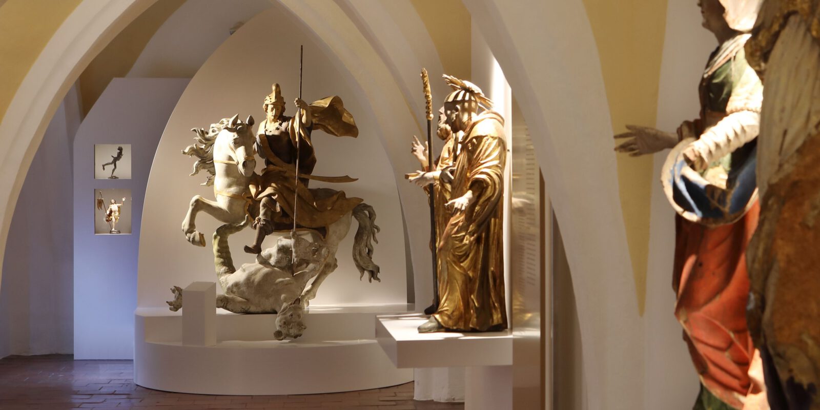 Kunststadt Burghausen - Skulpturen Blick in eine Halle mit geschnitzten Figuren aus Kirchen und Klöstern